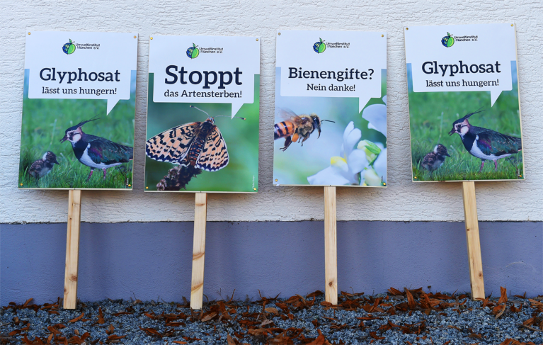 Schilder mit Slogans gegen industrielle Landwirtschaft und Artensterben