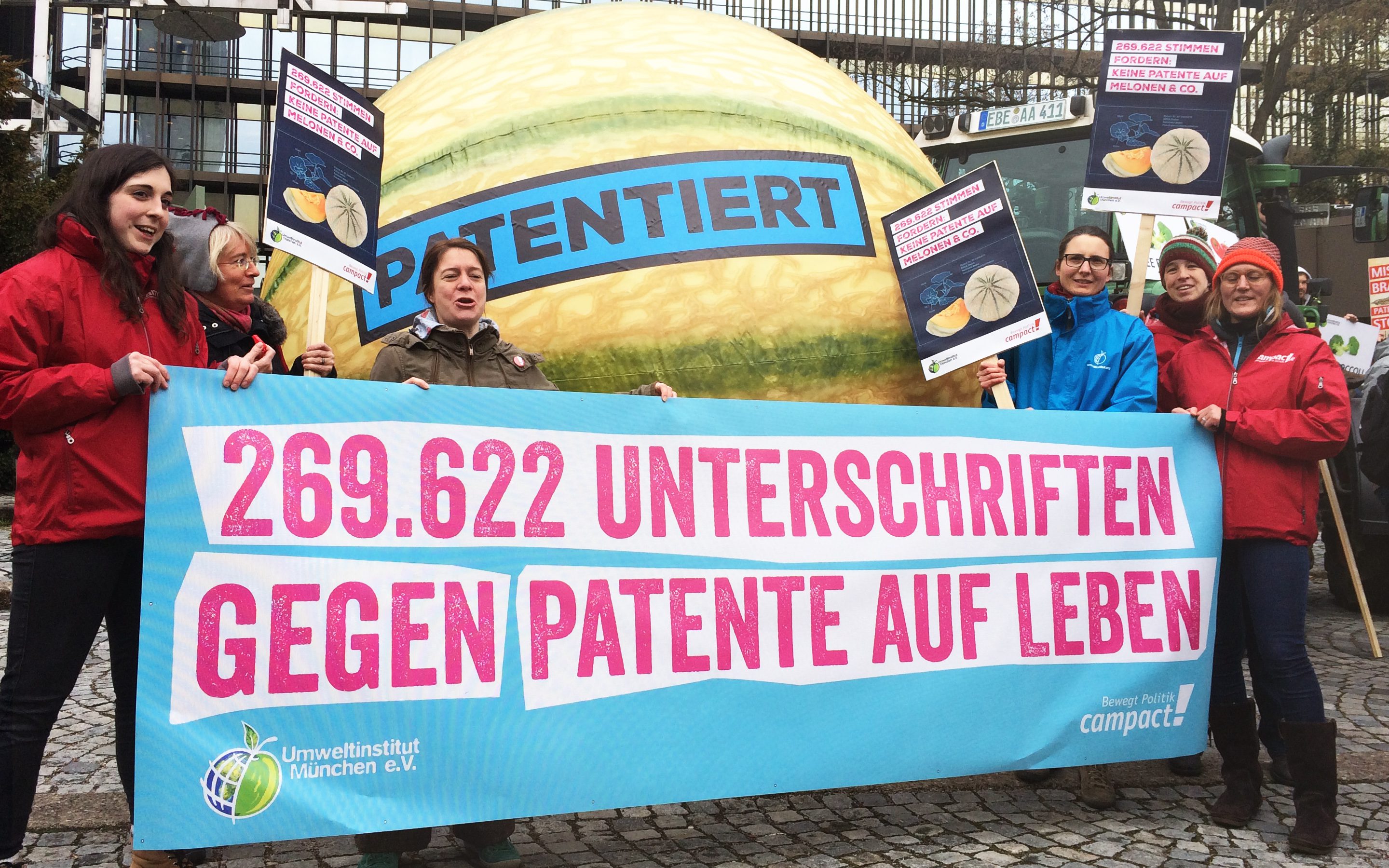 Aktion gegen Patente auf Leben mit einem Banner mit über 250.000 Unterschriften, Schildern und einem 2 Meter großen Melone mit der Aufschrift 