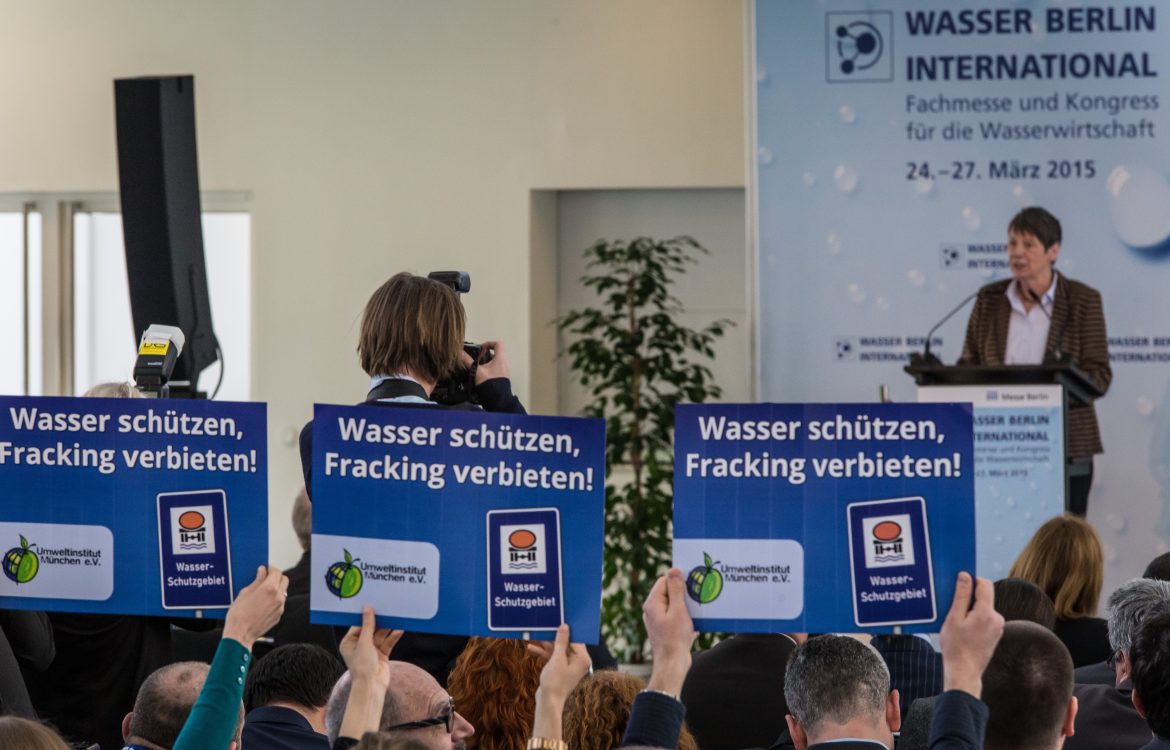 Rednerin bei Fachmesse und Kongress für Wasserwirtschaft in Berlin im Jahr 2015 vor Demonstrant:innen und Fotograf:innen.