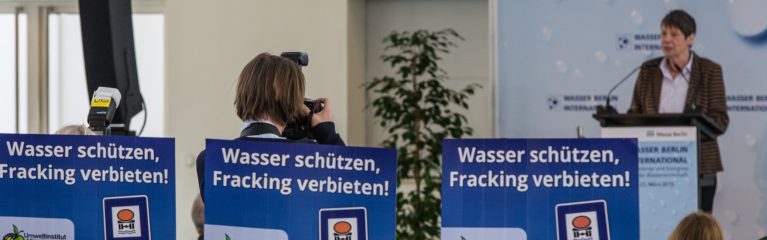 Rednerin bei Fachmesse und Kongress für Wasserwirtschaft in Berlin im Jah 2015 vor Demonstrant:innen und Fotograf:innen.
