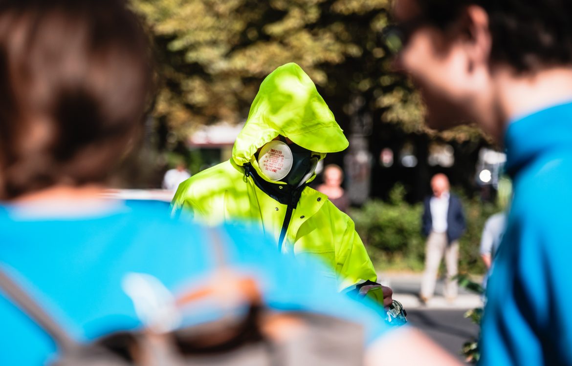 Mann mit Schutzweste und Gasmaske auf der Übergabeaktion gegen Glyphosat in Berlin