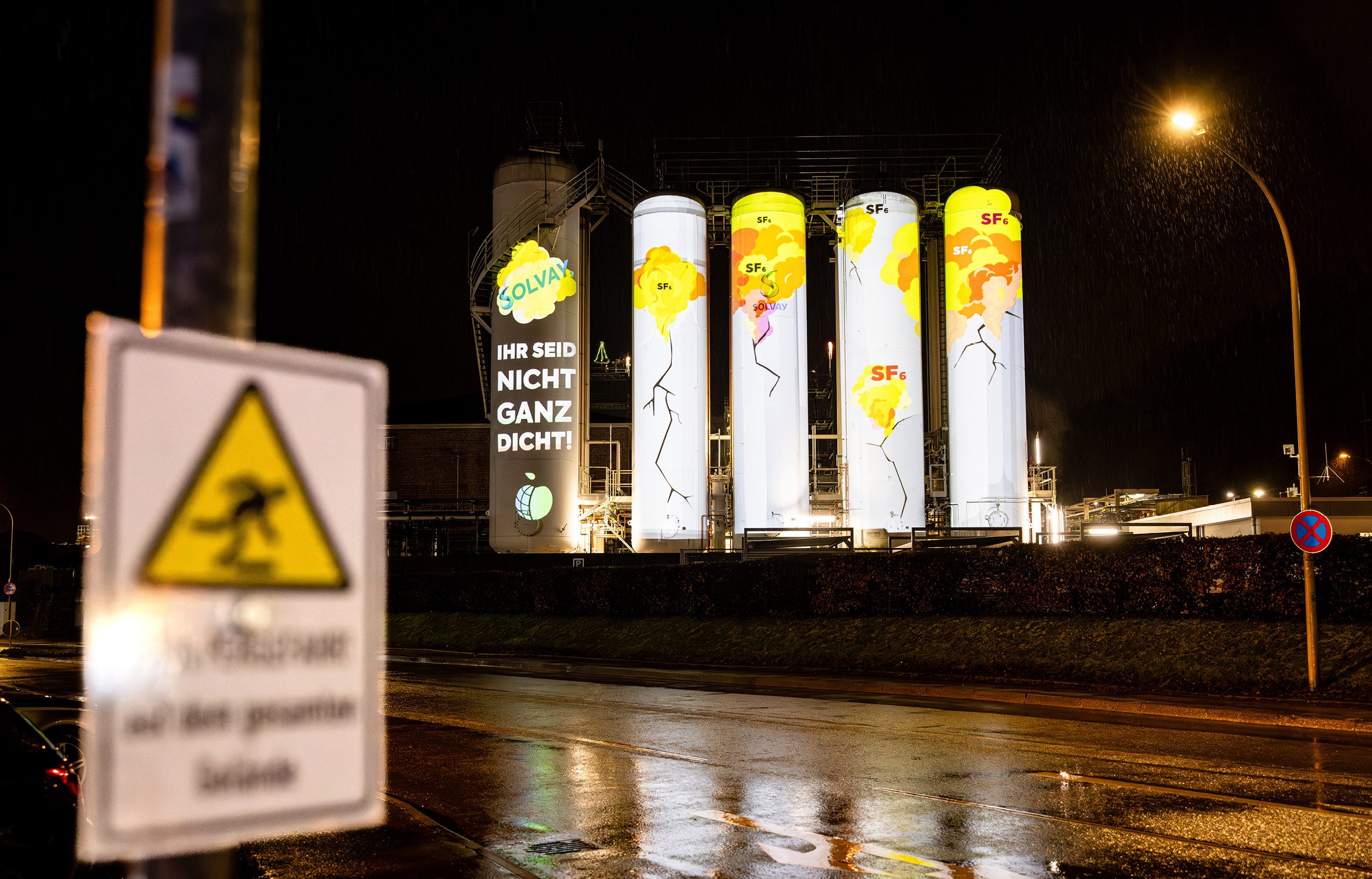 Projektion von Rissen und Spruch Ihr seid nicht ganz dicht auf Tanks der Solvay Chemiefabrik