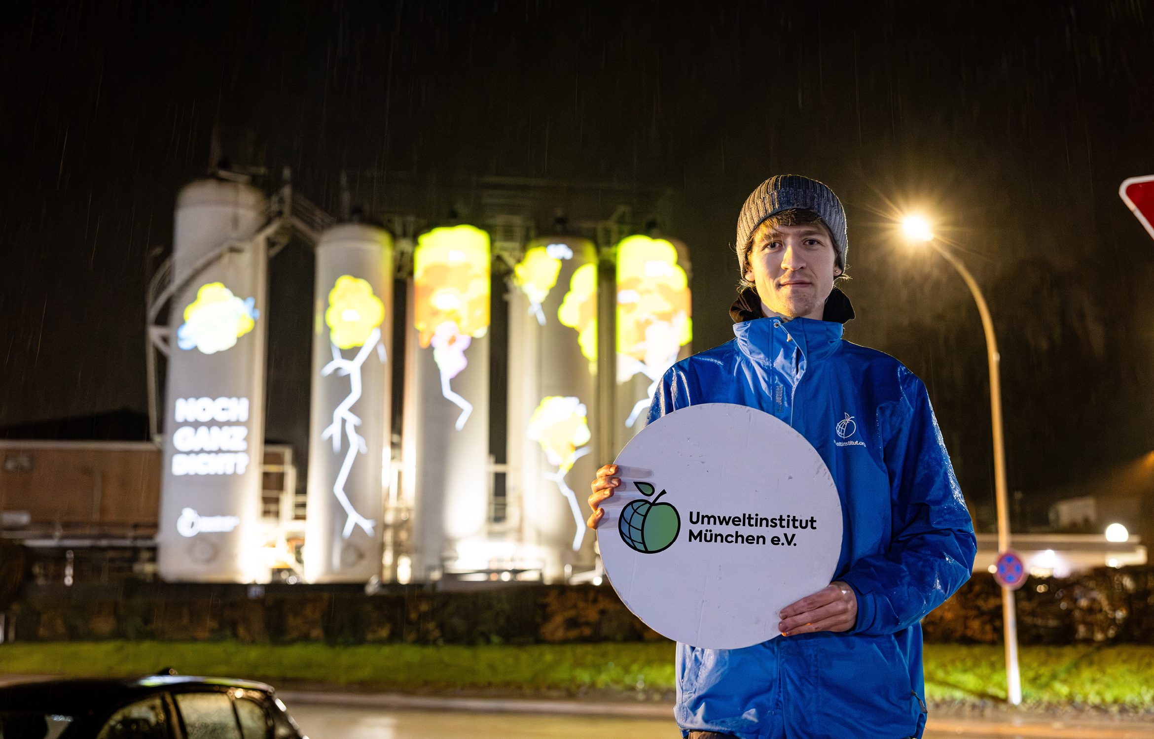 Klimareferent Till Irmisch vom Umwetlinstitut vor der Projektion von Rissen und Spruch Ihr seid nicht ganz dicht auf Tanks der Solvay Chemiefabrik